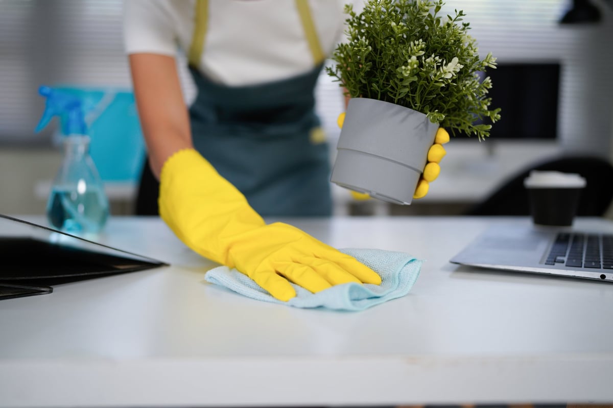Cleaning professional wiping down a table in a commercial office