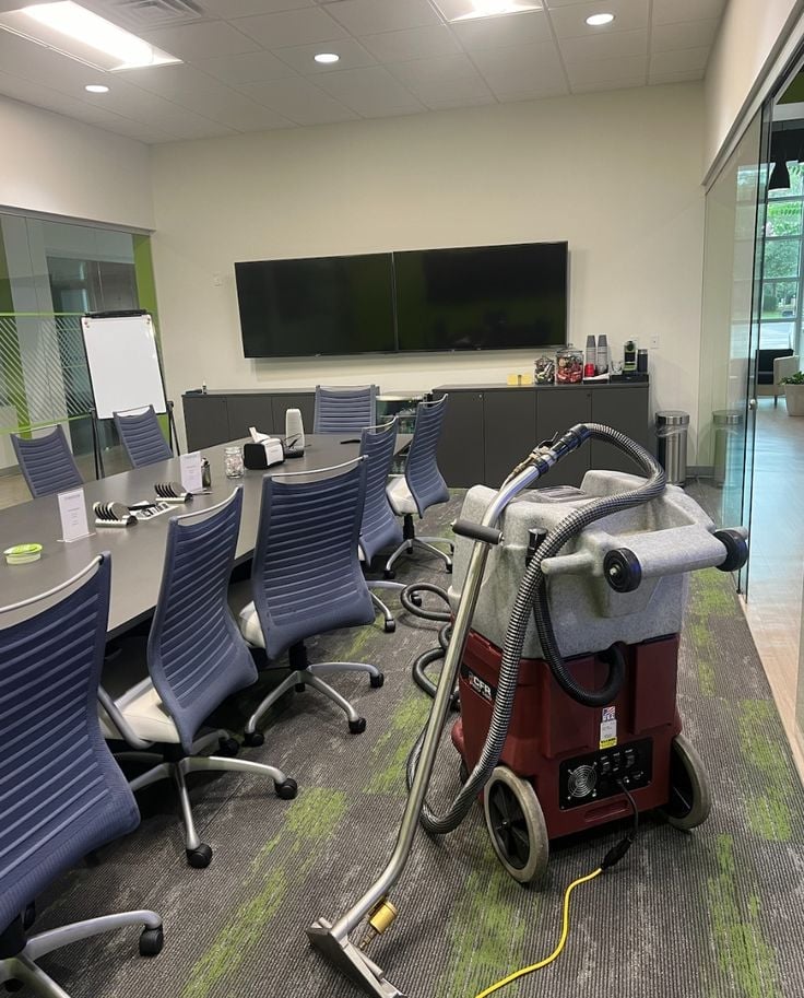 Commercial carpet extractor staged in a modern office conference room for a deep-cleaning service